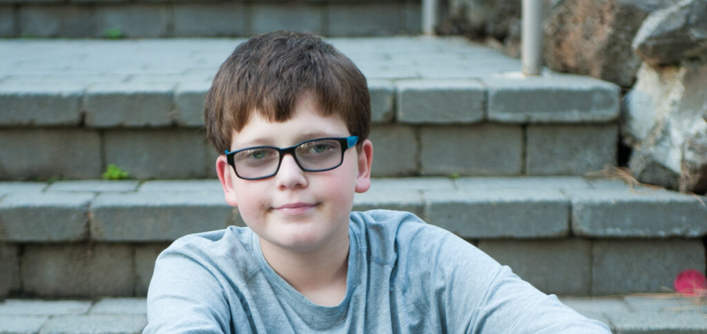 young boy sitting on a stair case